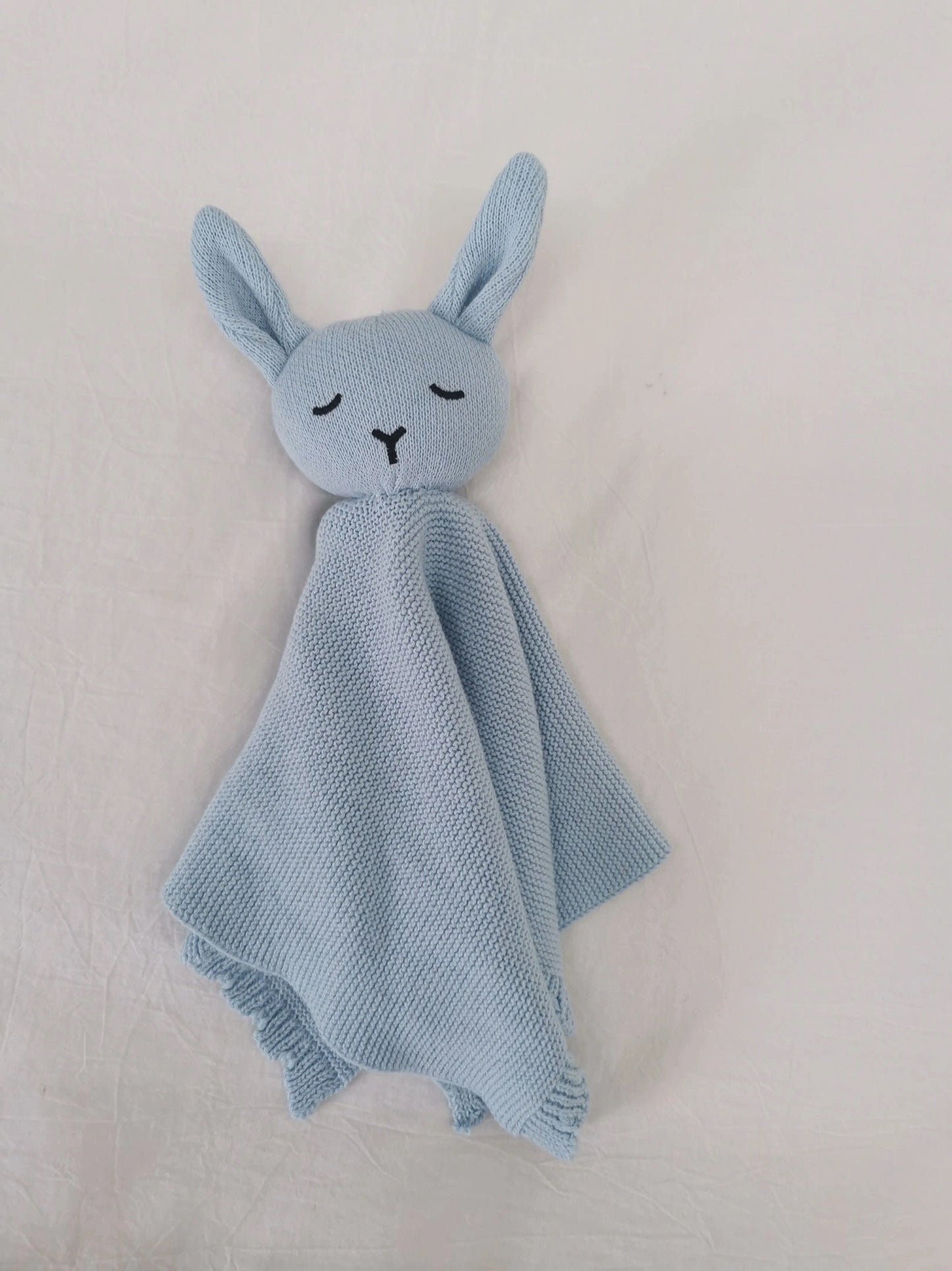 Baby blue knitted bunny comforter lovey blanket with scalloped edge detail.