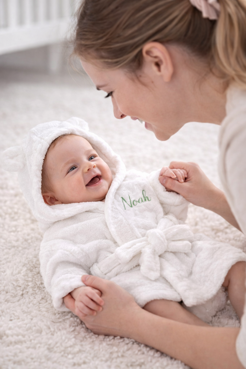 Personalised hooded baby bathrobe styled with nursery items β perfect baby shower and Aqiqah gift in the UAE