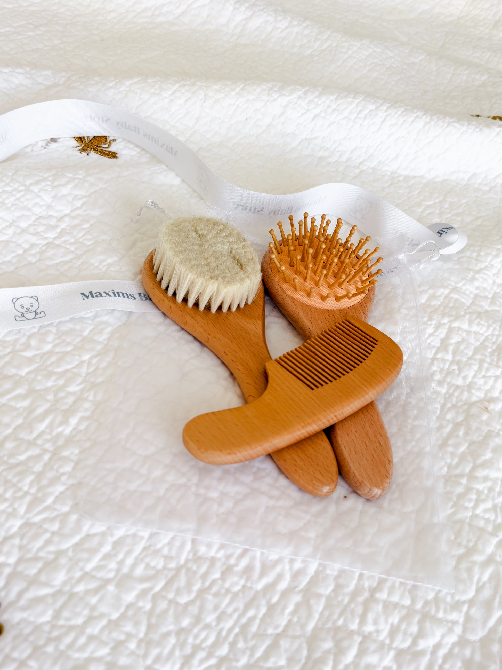 Maxims Gift Co. branded gift ribbon with 3-piece wooden baby brush and comb set — premium baby gift in the UAE
