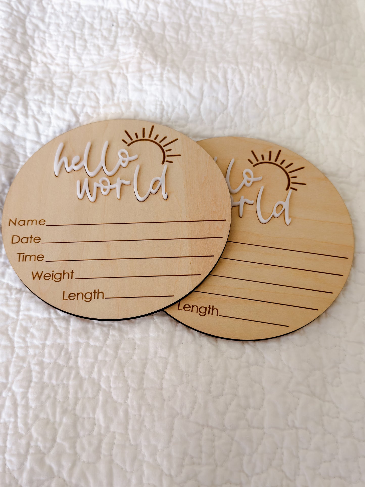 Close-up of beechwood milestone disc with white "hello world" raised lettering and engraved sunburst detail — Maxims Gift Co. UAE
