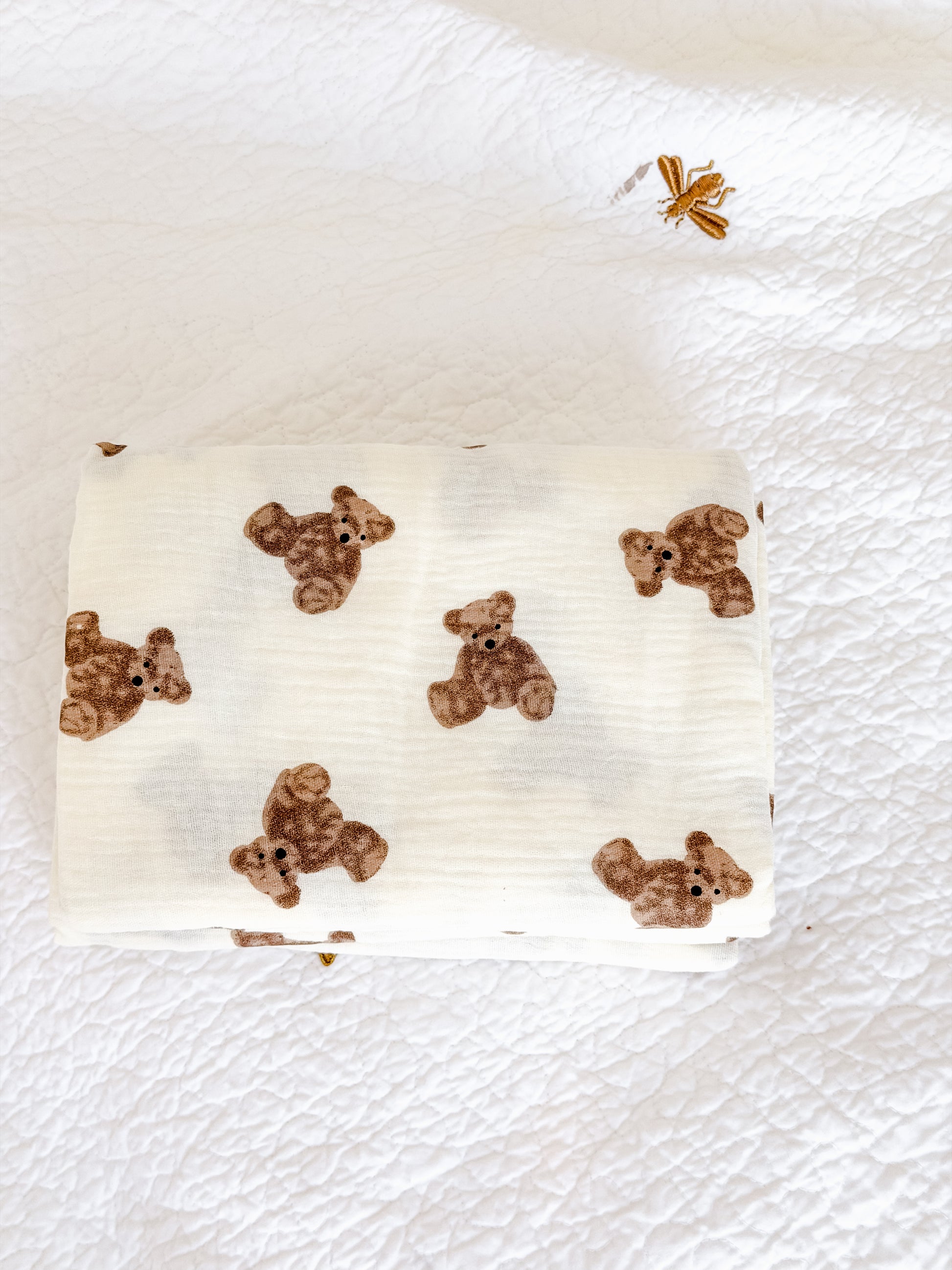 Cream muslin baby blanket spread flat showing soft double-layer cotton fabric with teddy bear print — perfect newborn swaddle in Dubai
