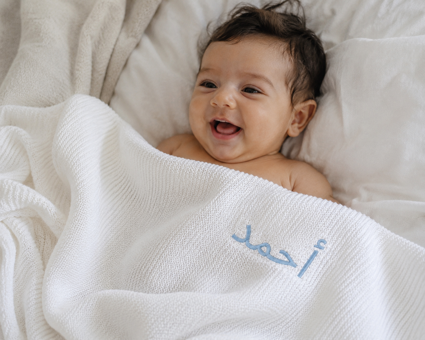 Close-up of English name embroidery on soft white bamboo cotton baby blanket — Maxims Gift Co. personalised newborn gift
