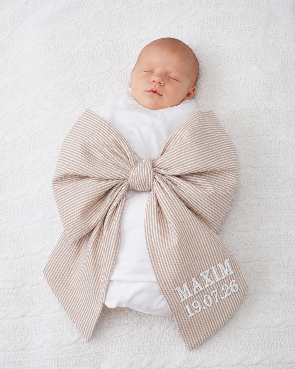 Newborn baby wrapped in personalised beige stripe bow sash with custom embroidery — Maxims Gift Co. Dubai UAE 