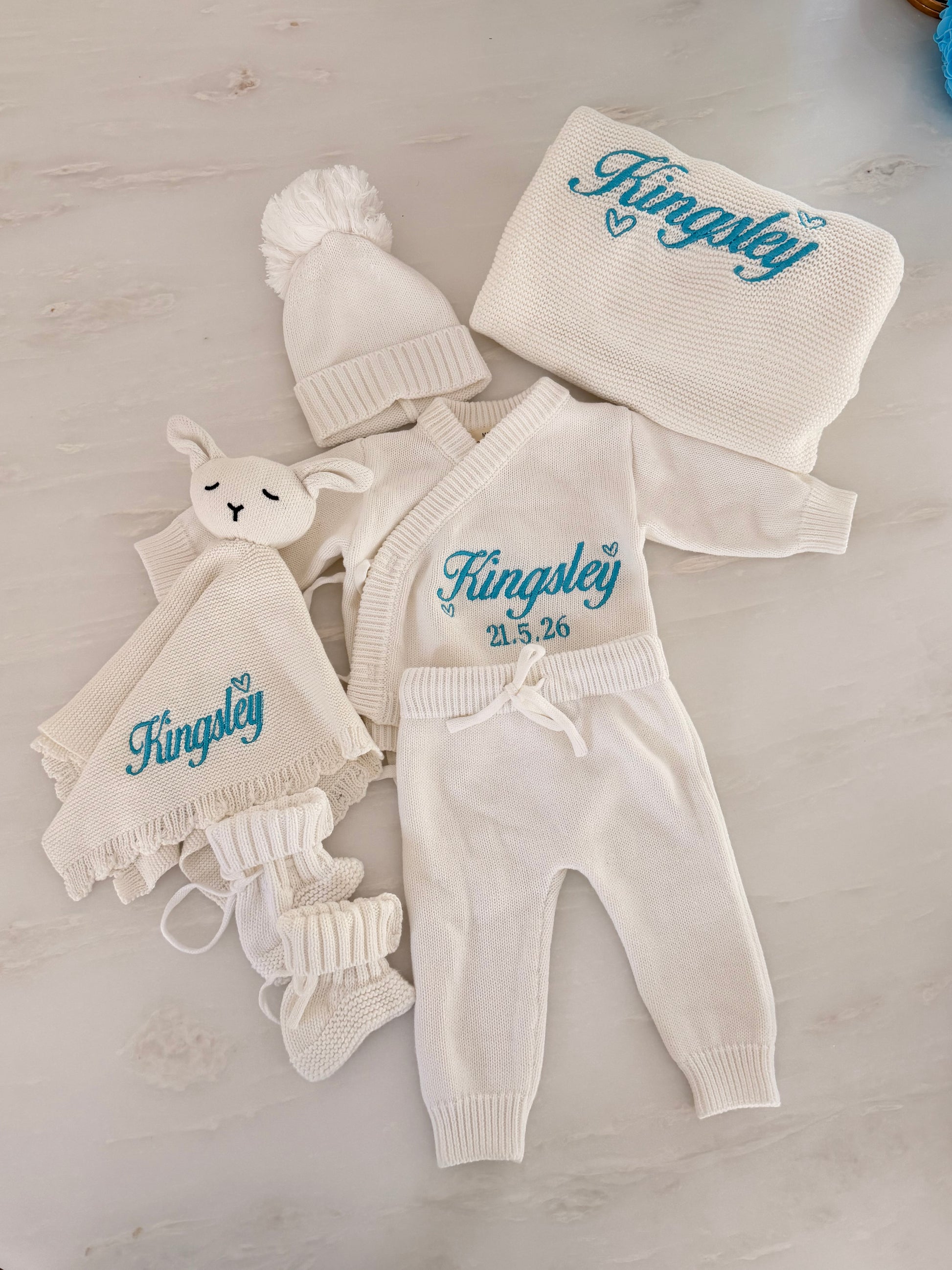 Personalised luxury newborn knit gift box with embroidered name Kingsley and birth date in blue