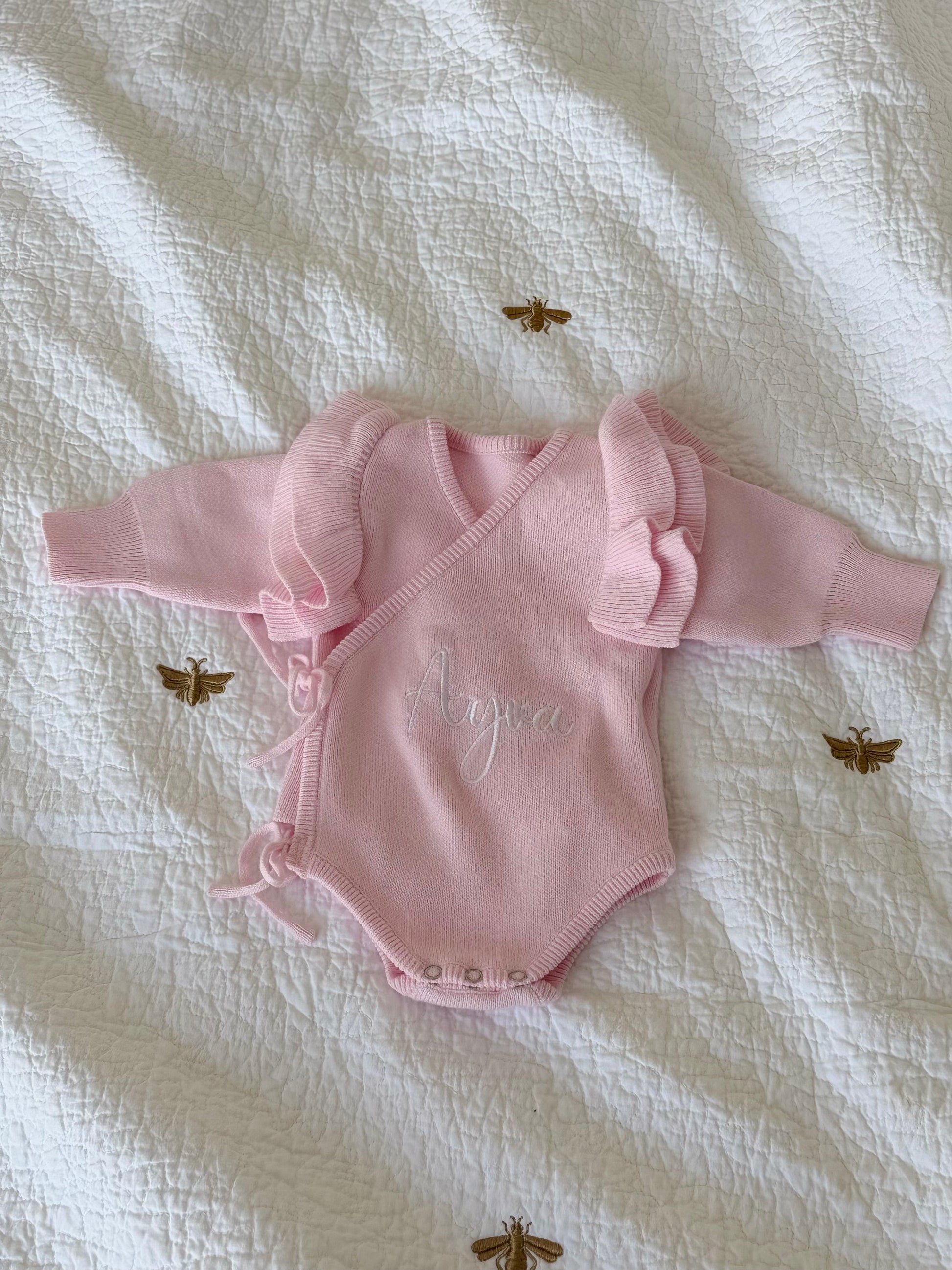 Personalised pink organic cotton knit wrap romper with embroidered name and ruffle sleeves — Maxims Gift Co. newborn gift Dubai UAE
