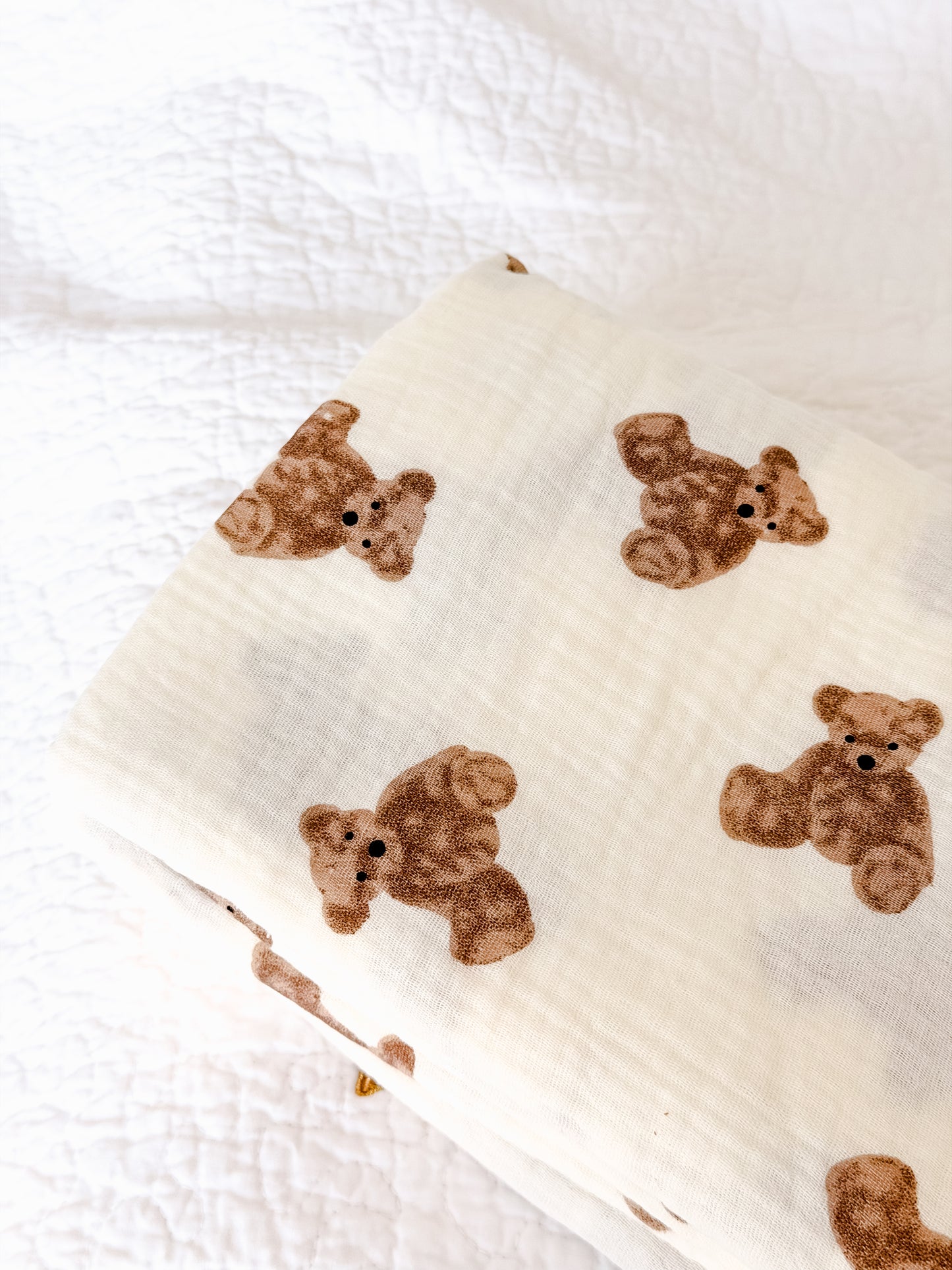Close-up detail of cream muslin baby blanket showing brown teddy bear print on soft cotton fabric — Maxims Gift Co. baby essentials UAE
